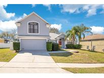 Charming two-story home featuring a well-manicured lawn and an attached two-car garage at 511 Coventry Rd, Davenport, FL 33897