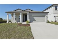 Charming single-story home featuring a manicured lawn, covered entry, and two car garage at 5713 Haystack Dr, St Cloud, FL 34771