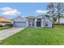 Charming single-story home featuring a well-manicured lawn, neutral paint, and attached two-car garage at 843 Julliard Ct, Orlando, FL 32828