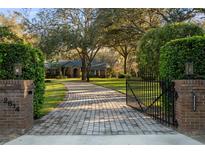 Charming home with a long paved driveway framed by lush landscaping and a gated entrance at 2614 W Ponkan Rd, Apopka, FL 32712