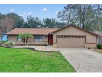 Charming single-story home featuring a two-car garage, well-manicured lawn and tasteful landscaping at 2643 Nova Dr, Apopka, FL 32703