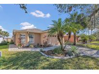 Charming home exterior with a well-maintained lawn, paved driveway, and beautiful palm trees at 340 Grand Canal Dr, Poinciana, FL 34759