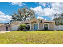 Charming single-story home featuring a well-manicured lawn and a welcoming blue front door at 970 Picasso Ave, Deltona, FL 32738