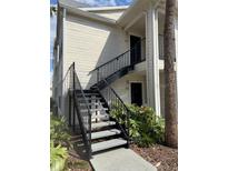 Condo exterior featuring staircase access and beige siding, providing convenient access to upper-level units at 1055 S Hiawassee Rd # 2027, Orlando, FL 32835