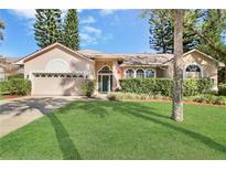 Charming single-story home featuring a well-manicured lawn, arched windows, and a two-car garage at 107 Springhurst Cir, Lake Mary, FL 32746