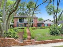 Charming two-story brick home featuring a lush front yard and inviting balcony at 1804 Wind Willow Rd, Belle Isle, FL 32809