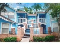 Charming blue townhouse with brick accents, inviting stairs and a well-maintained exterior at 2739 N Poinciana Blvd # 84, Kissimmee, FL 34746