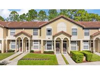 Charming townhouse with terra cotta roof, manicured lawn, and inviting curb appeal at 6007 Scotchwood Gln # 37, Orlando, FL 32822