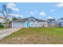 Charming single-story home showcasing a well-maintained lawn and bright blue front door at 647 Holbrook Ave, Deltona, FL 32738