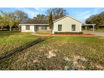 Charming single-story home featuring a well-maintained lawn and a screened-in porch at 15525 Seymour Ln, Groveland, FL 34736