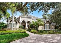Elegant home exterior featuring a lush, landscaped front yard and a brick driveway leading to the main entrance at 1613 Glenwick Dr, Windermere, FL 34786