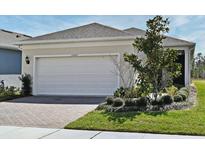 Charming one-story home with a spacious two-car garage, brick driveway and neatly landscaped front yard at 17667 Saw Palmetto, Clermont, FL 34714