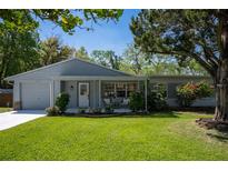 Charming single-story home featuring a well-manicured lawn, covered porch, and inviting curb appeal at 1832 Magnolia Ave, Winter Park, FL 32789