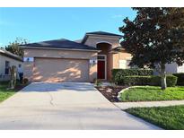 Charming single-Gathering home with landscaped front yard and attached two-car garage at 1862 Great Falls Way, Orlando, FL 32824