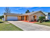 Charming single-story home featuring a two-car garage, stucco siding and a well-manicured lawn at 209 Georgetowne Blvd, Daytona Beach, FL 32119