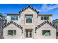 Elegant two-story home featuring a stone facade and modern windows, set against a vibrant blue sky at 3206 Harrison Ave, Orlando, FL 32804