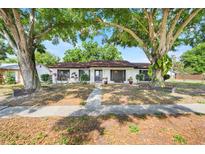 Charming single-story home featuring mature trees, a well-maintained lawn, and a welcoming entryway at 5202 Greenway Drive, Orlando, FL 32819