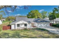 Charming single-story home featuring a well-manicured lawn, three-car garage, and neutral exterior paint at 6735 Edgeworth Dr, Orlando, FL 32819