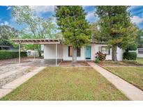 Charming single-story home featuring a covered carport, blue front door, and well-maintained front yard at 7121 Stockholm Way, Orlando, FL 32822