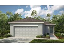 Charming one-story home featuring an attached two-car garage and a well-manicured lawn at 7359 Capstone Dr, Groveland, FL 34736
