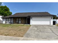 Charming single-story home features a stone accent wall, two-car garage, and well-maintained lawn at 7508 Covedale Dr, Orlando, FL 32818