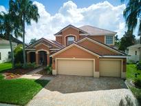 Beautiful two-story home with a well-maintained lawn, a paver driveway, and an attached garage at 2341 Baronsmede Ct, Winter Garden, FL 34787