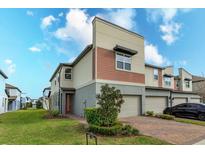 Inviting modern home with a two-car garage, brick driveway, neutral tones, and manicured landscaping at 2472 Firstlight Way, Winter Park, FL 32792