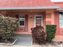 Charming single story home showcasing a peach exterior, tidy landscaping, and a welcoming front door at 2727 W Oak Ridge Rd # 5-6, Orlando, FL 32809