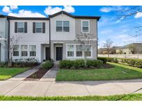 Inviting townhouse exterior with well-maintained lawn and modern architectural details at 3270 Water Sprite St, Orlando, FL 32808