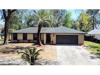 Charming single-story home with a well-maintained yard and mature landscaping and a two car garage at 5443 Aeolus Way, Orlando, FL 32808