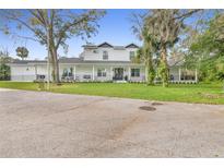 Charming two-story home features a welcoming porch, mature trees, and well-maintained landscaping at 599 Glendevon Dr, New Smyrna Beach, FL 32168