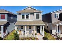 Charming two-story home features a welcoming front porch with a well-manicured lawn and beautiful landscaping at 6404 Pine Fork Aly, St Cloud, FL 34771