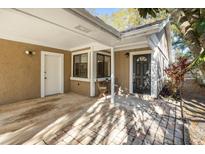 Charming front entrance with covered patio and brick pathway to a dark-colored front door at 703 Linden Dr, Winter Springs, FL 32708