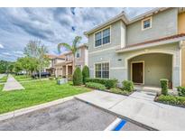 Inviting two-story townhome with a well-manicured lawn and covered front porch at 8962 Sugar Palm Rd, Kissimmee, FL 34747