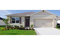 Charming one-story home with a well-manicured lawn, two car garage, and inviting curb appeal at 907 Princess Sabal Pt, Haines City, FL 33844