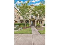 Charming two-story townhouse featuring a covered front porch and well-maintained landscaping at 10566 Green Ivy Ln, Orlando, FL 32832
