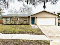 Charming single-story home with a well-maintained lawn, bright blue front door, and attached two car garage at 1197 Village Forest Pl, Winter Park, FL 32792