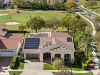 Aerial view of home featuring a tile roof, solar panels, a paver driveway, and lush landscaping at 13106 Alderley Dr, Orlando, FL 32832