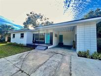 Charming single-story home features a carport, modern design, and a welcoming turquoise front door at 1416 Bennett Rd, Orlando, FL 32803