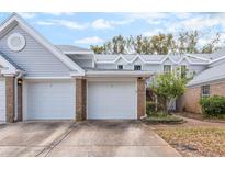 Charming townhome exterior featuring brick accents, multiple garages, and well-maintained landscaping at 2201 Coach House Blvd # 3, Orlando, FL 32812