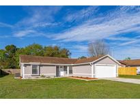 Charming single-story home featuring a well-manicured lawn and an attached two-car garage at 2740 Courtland Blvd, Deltona, FL 32738