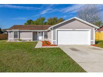 Charming single-story home with well-maintained lawn, gray exterior, and attached two car garage at 2740 Courtland Blvd, Deltona, FL 32738