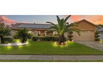 Charming single Gathering home featuring a well-maintained lawn, lush landscaping and solar panels at 8128 Hook Cir, Orlando, FL 32836