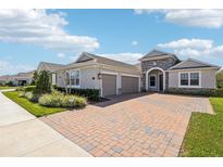 Charming single-story home featuring a two car garage, stone accents, and a brick paver driveway at 1098 Victoria Hills S Dr, Deland, FL 32724