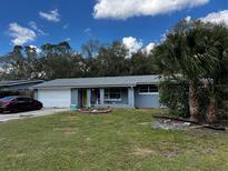 Charming single-story home with a well-maintained lawn, attached garage, and vibrant yellow front door at 1111 Hall Ln, Orlando, FL 32839