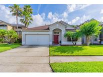 Charming single-story home with a well-manicured lawn and a red front door at 1401 Royal Saint George Dr, Orlando, FL 32828