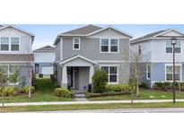 Charming two-story home with a manicured lawn and inviting front porch at 14146 Lanikai Beach Dr, Orlando, FL 32827