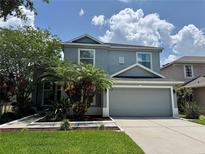 Charming two-story home with a gray exterior, a well-manicured lawn, and a two-car garage at 14415 Estrella Dr, Orlando, FL 32837