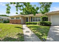 Charming single-story home featuring a brick accent wall and well-manicured landscaping at 1508 Avenue H Ne, Winter Haven, FL 33881