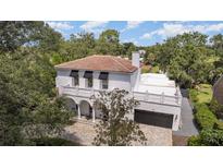An impressive exterior elevation view of a white two-story home with a clay tile roof and meticulously manicured landscaping at 1731 Windsor Dr, Winter Park, FL 32789